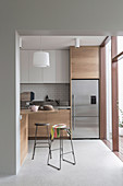 Glance into the kitchen, some with wooden fronts, stainless steel fridge and bar stools