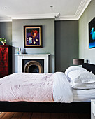 Grey walls, open fireplace and stucco frieze in classic bedroom