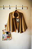 Cape with floral brooch hung from coat rack