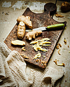 Ginger root and sliced ginger on rustic wooden board