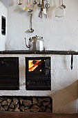 Kettle on wood-fired cooker in kitchen of mountain cabin