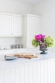 Bread and flower arrangement in bright country-house kitchen