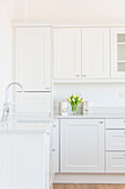 Empty white kitchen with panelled cabinet doors