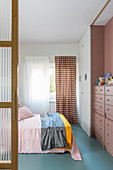 Blick ins Schlafzimmer mit hellblauem Boden und Retro-Style
