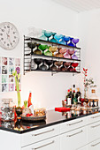 Christmas decorations on kitchen base unit below shelves of multicoloured glass goblets