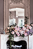 Mantelpiece decorated with roses and an antique mirror