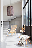 Rattan armchair, side table and stool below window