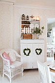 Wicker armchair next to white dresser with Christmas decorations