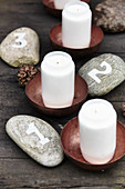 Advent arrangement handmade from numbered pebbles and candles