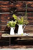Bunches of wildflowers in white enamel jugs