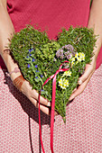 Herzförmiges Gesteck aus Blüten von Leinkraut, Frauenmantel, Majoran und Natterkopf