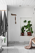 Houseplants in niche in bathroom with wood-panelled walls