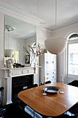 Dining table next to open fireplace in classic period building with stucco ceiling