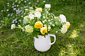 Spring bouquet of tulips, ranunculus and ox-eye daisies in jug