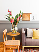 Flowers on side table and chair next to sofa