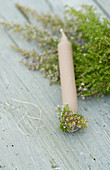 Sprigs of heather wrapped around candle base