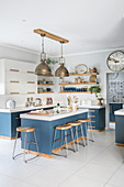 Blue base units and bar stools in modern country-house kitchen
