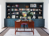 Antique desk in front of bookcase in study