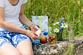 Woman peeling a boiled egg at a picnic