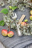 Cake fork with name tag amongst crab apples and clematis seed heads
