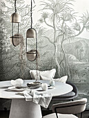 Round table, hanging plant pots above, in the background wallpaper with jungle motive