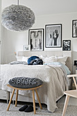 Beige and grey bedroom with black-and-white photos above bed