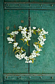 Cherry-blossom heart-shaped wreath on rustic cupboard door