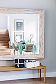 Modern dining room is reflected in the wall mirror with wooden frame