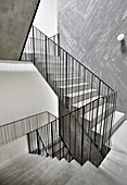 Concrete staircase with metal banisters in stairwell