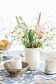 Japanese anemones and grasses in white vase