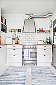 Blue-and-white rag rugs in white country-house kitchen