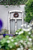 Old window frame with wreath and iron rod