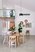 Esstisch im offenen Wohnraum mit Betonboden und Galerie