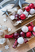 Red and white Christmas-tree baubles in wooden dishes on table