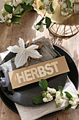 Sign reading 'Herbst' (autumn) and snowberries on plate