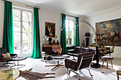 Braune Ledergarnitur und italienische Designerleuchte im Wohnzimmer, im Hintergrund Essbereicht mit großformatigem Gemälde