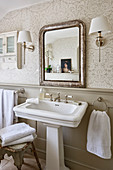 Antik Spiegel über Standwaschbecken und Vintage Hocker mit Handtüchern