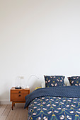 Bett mit blauer Bettwäsche und Nachttisch im Mid Century Stil