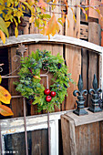 Door wreath with red apples, bound from mixed coniferous green