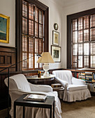 Hussensessel um halbrundem Tisch im Schlafzimmer mit originalen Fensterläden