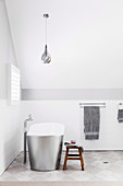 Freestanding bathtub in white attic bathroom
