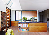 Elegante Küchenzeile mit Walnussholz-Fronten und Kücheninsel in offenem Wohnraum