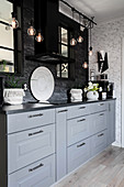 Pendant lamps in modern country-house kitchen in grey and black