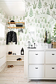 Leaf-patterned wallpaper and white wainscoting in foyer