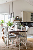 Various chairs around dining table in country-house kitchen