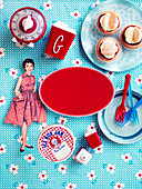 Papierpuppe und nostalgisches Küchenzubehör um rotes Etikett