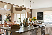 Concrete worktops in a kitchen with French pendant lights and glass storage jars