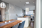 Langgestreckter offener Wohnraum mit Esstisch, Küchenblock und Couch