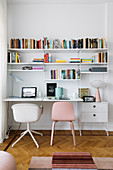 Two chairs below designer String shelves with integrated desk