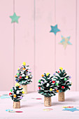 Miniature Christmas trees made from painted pine cones decorated with pompoms